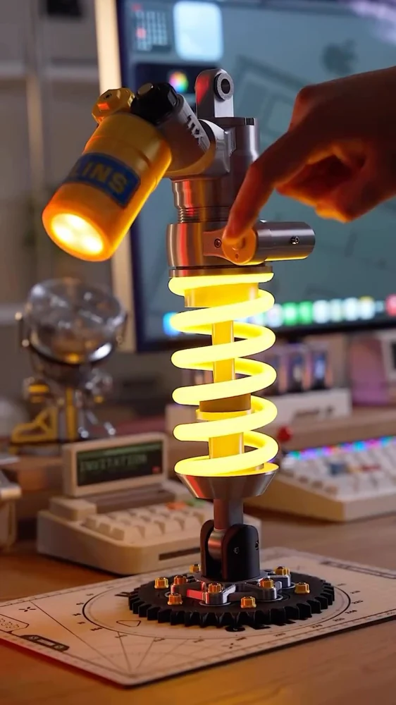 مصباح مكتبي LED مستوحى من ممتص صدمات الدراجات النارية، يجمع بين الإضاءة الهادئة والتصميم الميكانيكي المميز